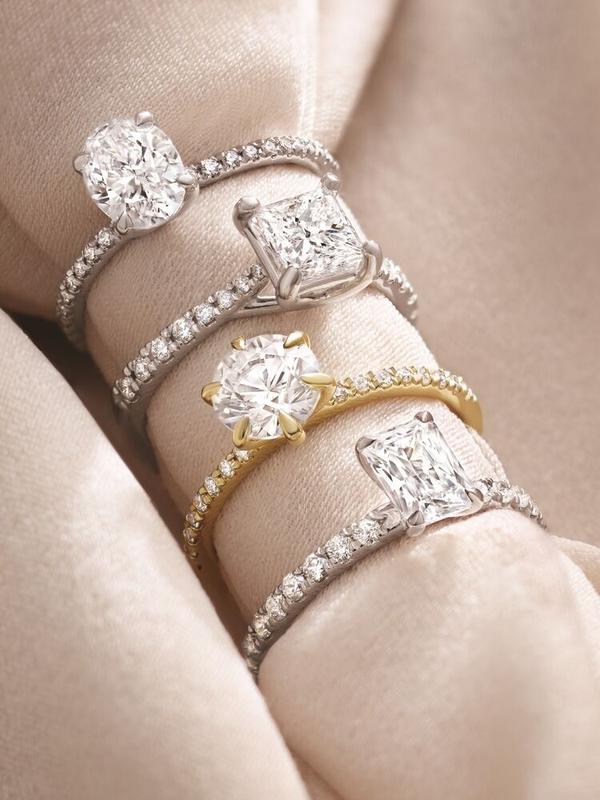 Diamond solitaire rings stacked on eternity bands