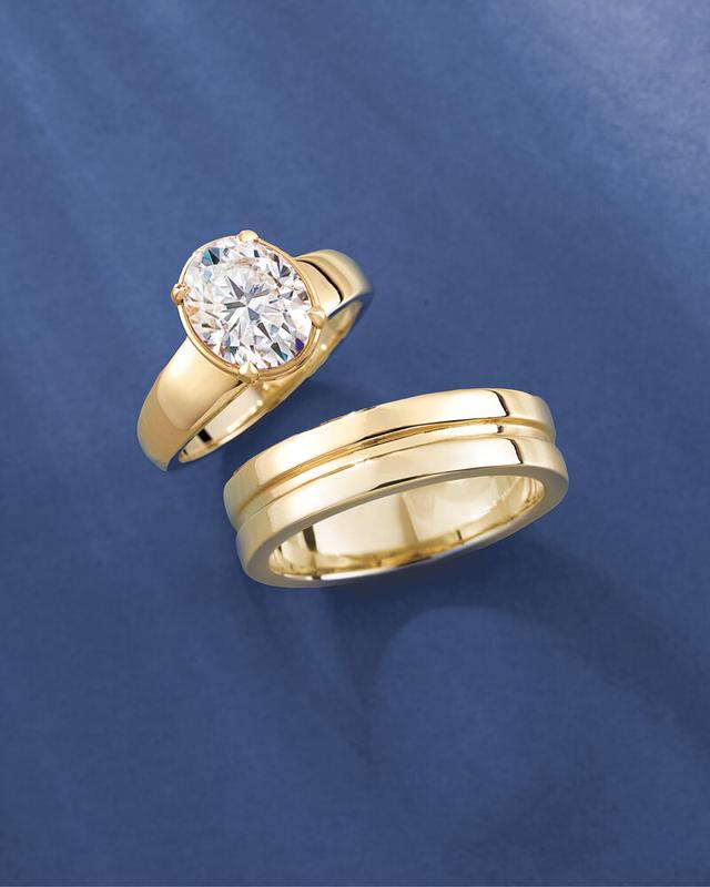 Oval diamond solitaire and men's wedding band in yellow gold