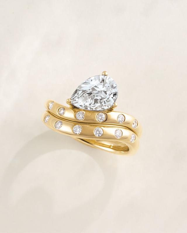 Pear diamond engagement ring with scattered-diamond bands