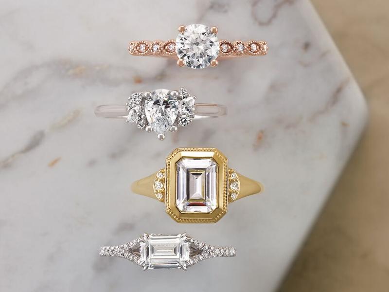Diamond engagement ring settings in mixed metals on marble