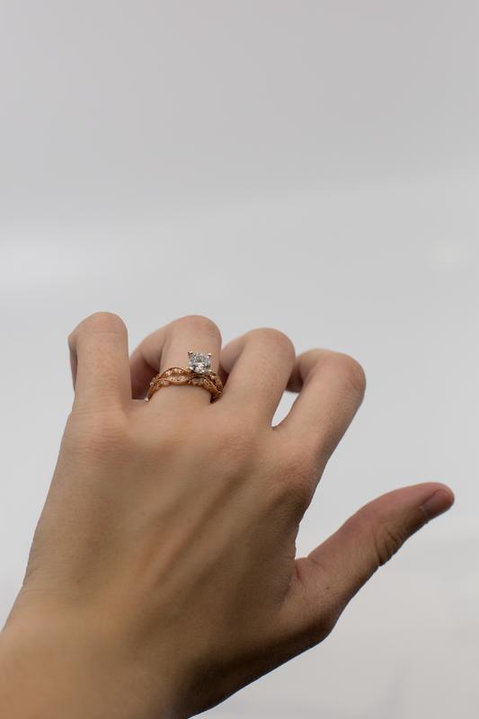 Diamond solitaire engagement ring held in hand