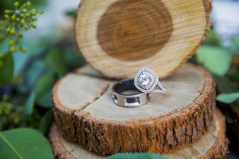 Diamond halo engagement ring and band on birch wood
