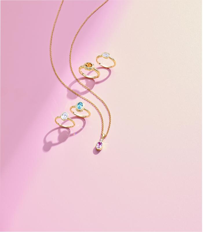 Gold rings and blue topaz drop necklace flat lay