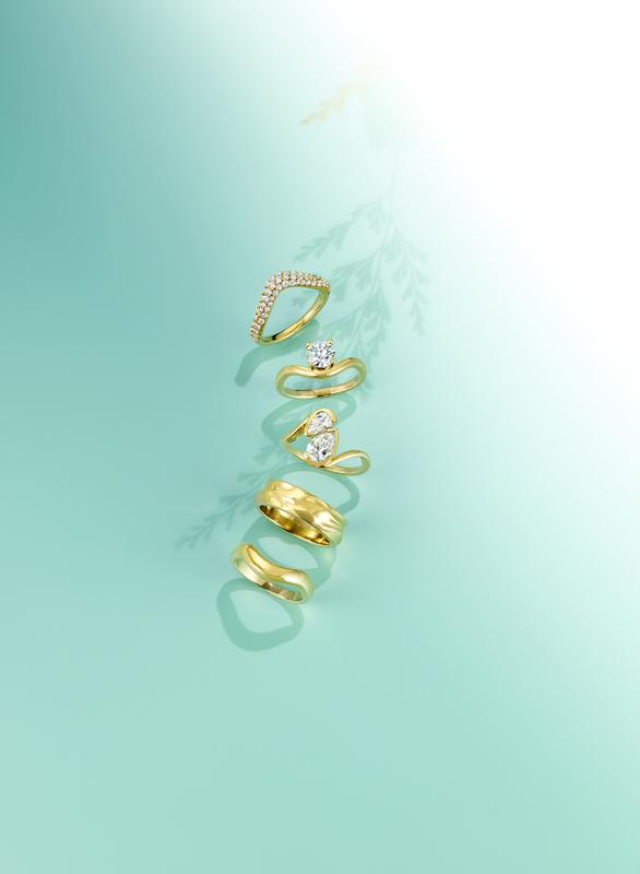 Gold stacking rings on mint background