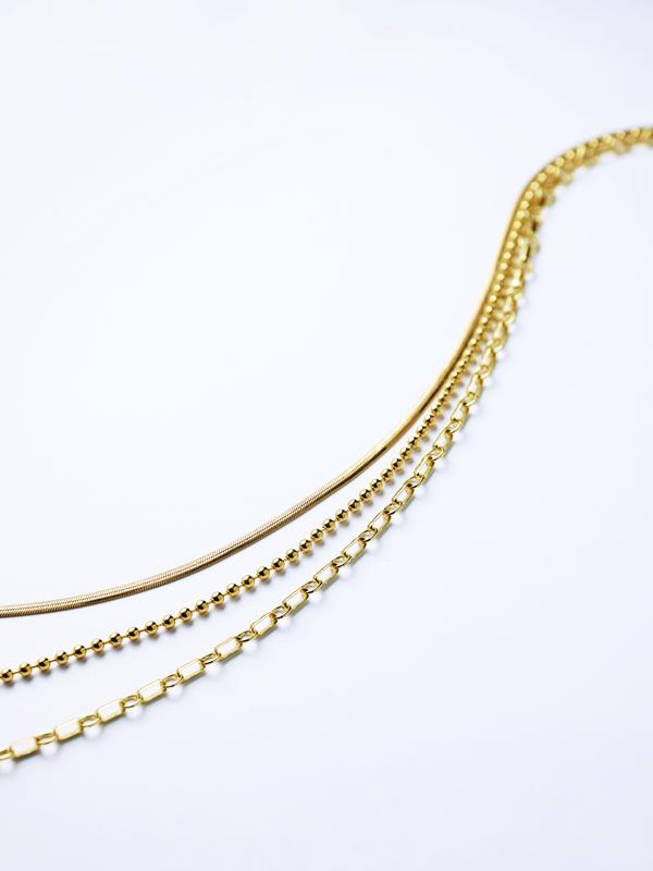 Layered gold chain necklaces close-up