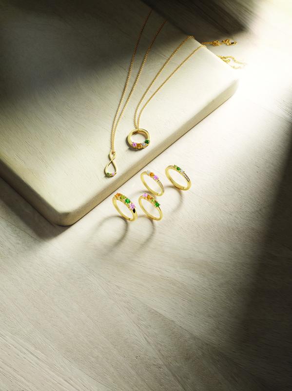 Gold gemstone rings and pendant necklaces in a tray