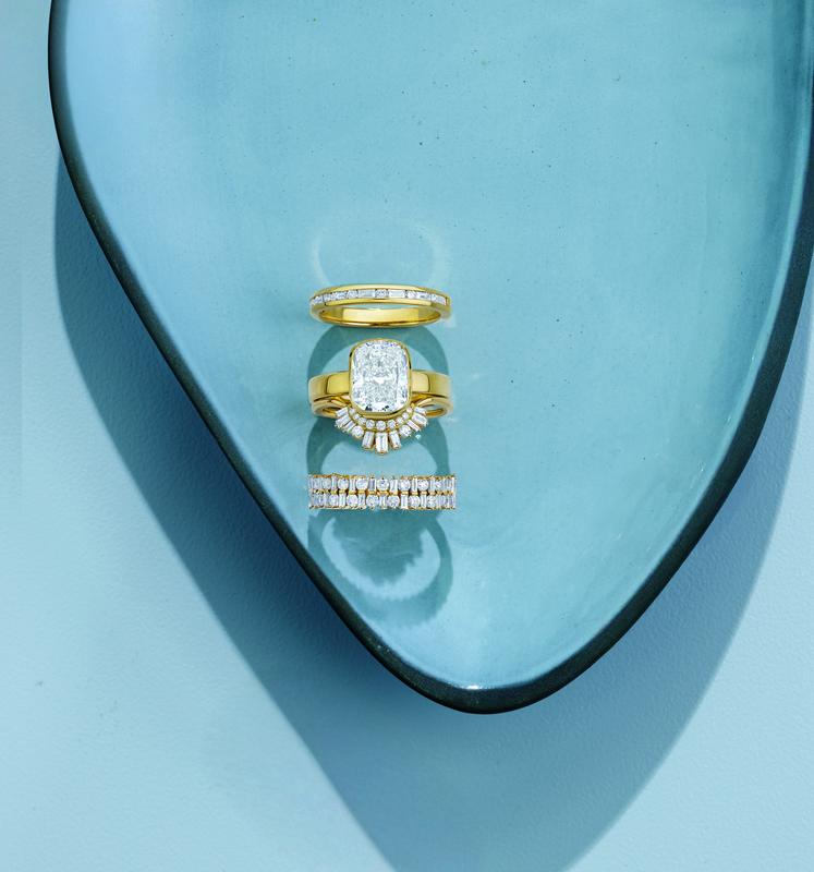 Emerald-cut bridal ring stack on blue dish